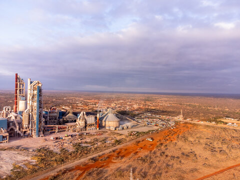 Aerial view of the Simba Cement Merueshi plant, featuring industrial structures, silos, and chimneys set against the arid landscape of Kajiado, Kajiado County, Kenya.