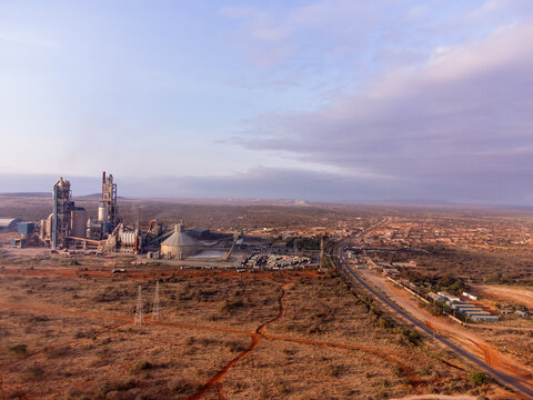 Aerial view of the Simba Cement Merueshi plant featuring large industrial silos and chimneys set against the arid landscape and red earth of Kajiado, Kajiado County, Kenya.