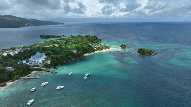 Aerial view of Cayo Levantado with its lush tropical vegetation, turquoise waters, and boats anchored near the resort in Samana, Dominican Republic.