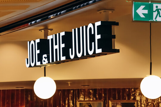 Monaco, Monaco - July 17, 2026: Illuminated Joe and The Juice sign and emergency exit direction sign inside Metropole Shopping Monte-Carlo