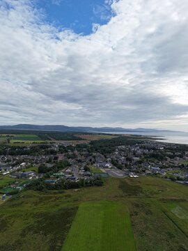 Dornoch is a picturesque Scottish town on Dornoch Firth, featuring a historic cathedral from 1224, ancient castle, blue skies, and beaches.