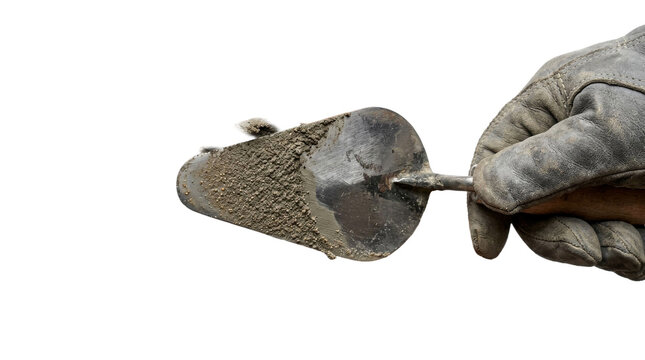 Worker's gloved hand holding trowel with cement on black background