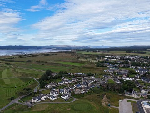 Dornoch is a historic Highland town in northern Scotland, seen from above with homes, streets, green landscapes, 1224 cathedral, and 1509 castle.