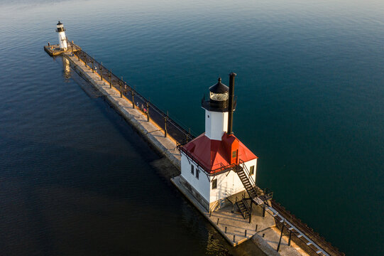 Aerial view of the St. Joseph North Pier lighthouses extending into Lake Michigan, featuring the white and red inner lighthouse and outer lighthouse in St. Joseph, Michigan, United States.