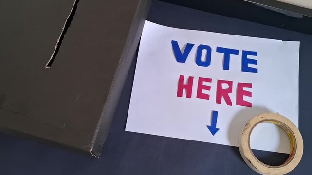 Vote here sign with black ballot box for election