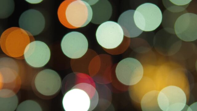 This video showcases a festive indoor setting with a Christmas bokeh effect created by soft lighting, featuring white and orange decorations that enhance the celebratory atmosphere. The scene is seta.