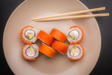 Symmetrical Arrangement of Salmon Sushi Rolls on Round Plate © Ilias