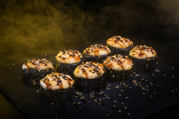 Baked Black Sushi Rolls Set with Sesame Seeds on Dark Background © Ilias