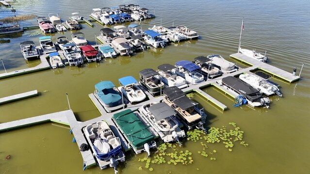 Aerial view of pontoon boats docked at a marina with lily pads in the water in Eustis, Florida, United States.
