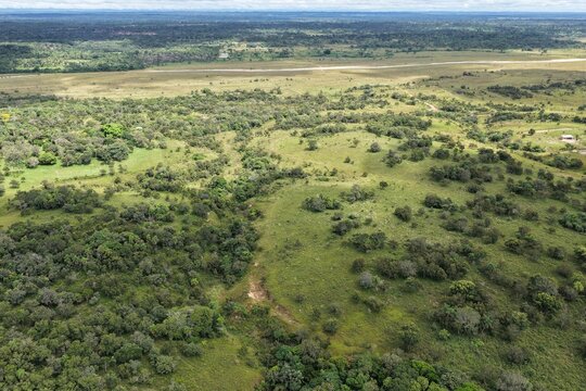 Vista a&eacute;rea de dron sobre paisaje rural con campos verdes, bosques y el rio.