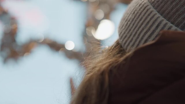 Cold festive winter scene depicted. Closeup of woman with festive winter accessories. Frosty holiday atmosphere showcasing woman adorned with sparkling winter ornaments and accessories
