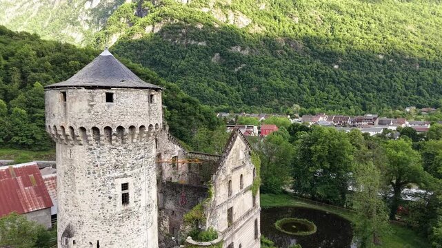 Plan a&eacute;rien en drone de la forteresse de S&eacute;chilienne, mettant en valeur sa tour historique et son architecture ancienne au c&oelig;ur d&rsquo;un paysage verdoyant et montagneux.