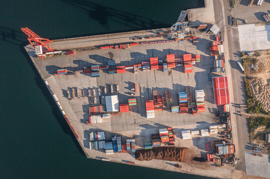 Aerial view of the port of Vilagarcia de Arousa with colorful shipping containers, industrial cranes, and cargo storage areas along the waterfront in Vilagarcia de Arousa, Pontevedra, Spain.