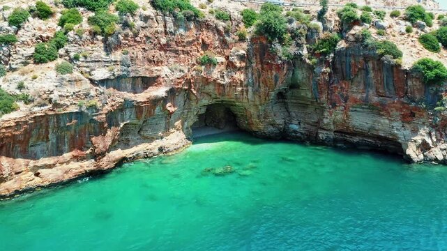 Blue Cave Finike Antalya aerial view showcasing a famous Mediterranean sea cave destination. Dramatic drone shot capturing vibrant turquoise water and rocky coast.