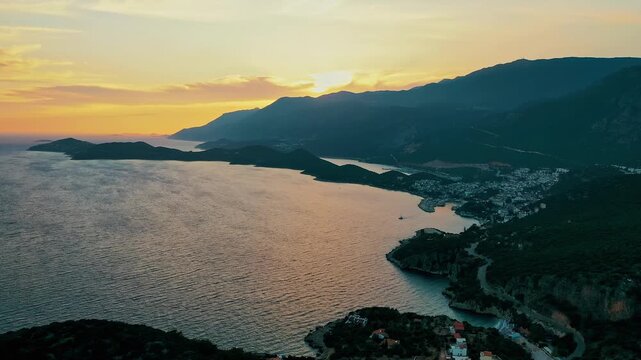 Kas Antalya coastal sunset aerial view highlighting dramatic red horizon and calm Mediterranean water. Cinematic drone camera moving toward the sea.