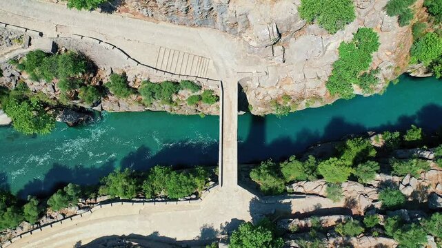 Koprulu Canyon aerial drone view reveals turquoise river waters winding through dramatic cliffs and lush forests in Manavgat, Antalya, Turkey.