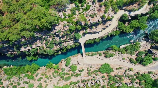 Koprulu Canyon aerial drone view reveals turquoise river waters winding through dramatic cliffs and lush forests in Manavgat, Antalya, Turkey.