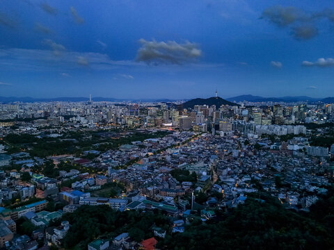 Aerial view of the sprawling urban landscape of Seoul at dusk, featuring the illuminated N Seoul Tower on the mountain and dense city lights, Seoul, Seoul, South Korea.