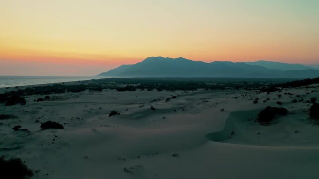 Patara sand dunes sunset aerial view capturing the dramatic golden hour light over the vast desert-like landscape in Antalya, Turkey. Majestic drone shot of coastal dunes.