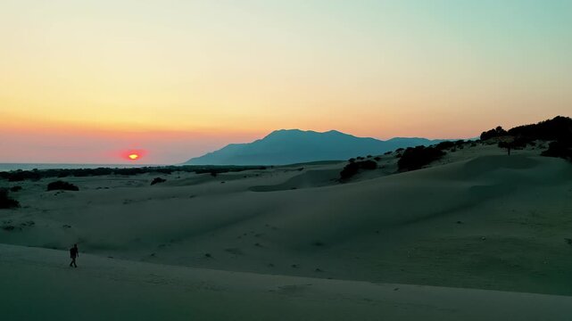 Patara sand dunes sunset aerial view capturing the dramatic golden hour light over the vast desert-like landscape in Antalya, Turkey. Majestic drone shot of coastal dunes.