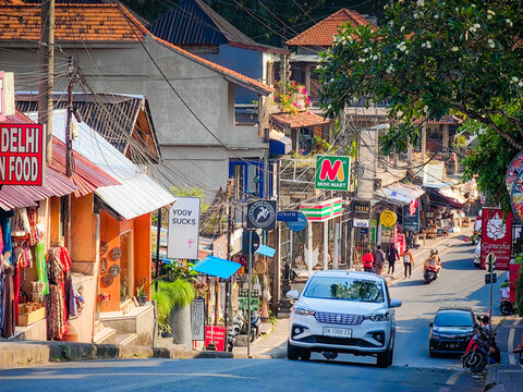 08 02 2026 - Ubud, Bali. Busy street in Ubud, Bali, Indonesia, lined with numerous shops, colorful advertising signs and local businesses, the vibrant atmosphere of a popular tourist destination