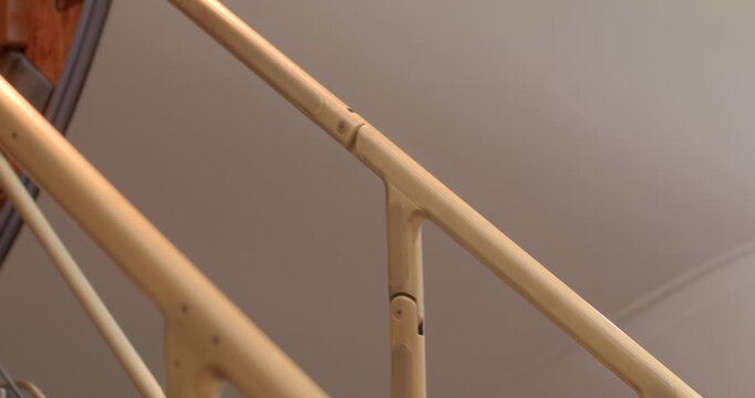 Closeup view of skilled technician inspecting stair fittings in hangar. Polished brass handrail on jet stairs wood door with maintenance technician conducting detailed inspection
