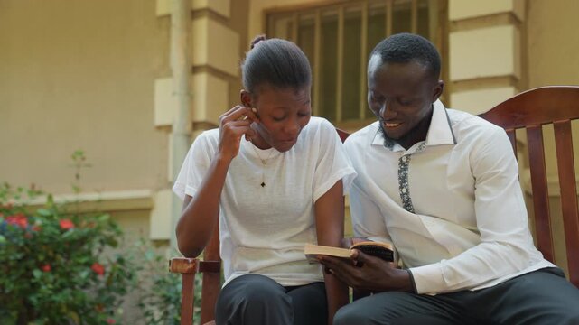 Sunlit porch couple sharing book, black couple on lighthearted date laughing over pages and notes close smiles, playful glances, gentle hand gestures, garden blooms behind bench, casual outfits, warm