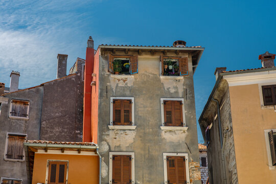 Mediterranean building facades with brown shutters in Rovinj, Croatia.