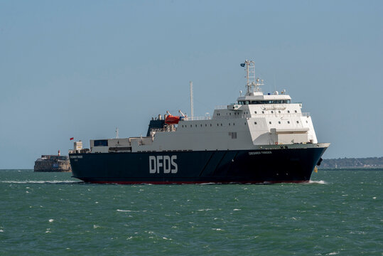 Portsmouth England UK. 05.08.2026. A large DFDS cargo ferry named 'Caesarea Trader' navigates through green, choppy waters with a historic fort in the distance