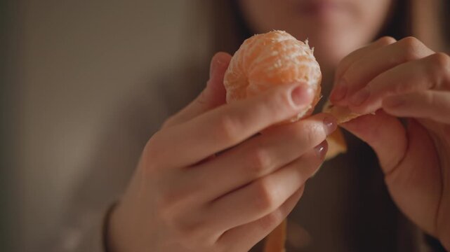 Closeup fingers removing mandarin peel slowly, detailed view of pith and spiral strip, neutral background and warm soft light, careful manual motion with ASMR vibe, mindful routine in quiet kitchen