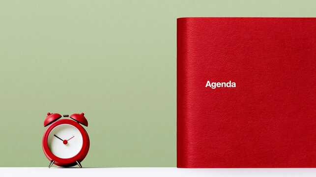 Agenda notebook with red alarm clock on green background