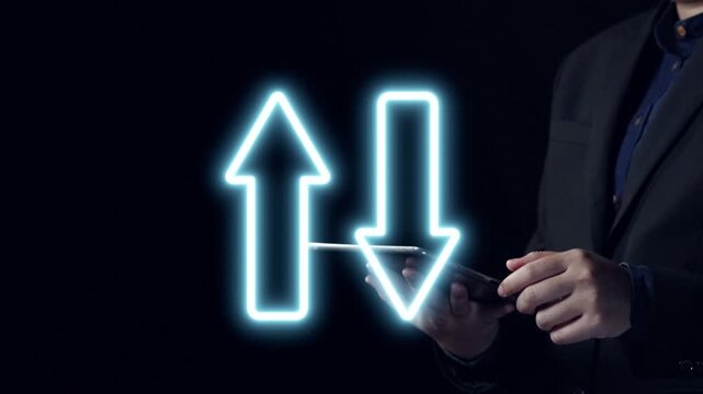 A businessman interacts with a smartphone while colorful neon arrows represent quality and cost factors, illustrating investment and economic strategies in a professional context. Qubit