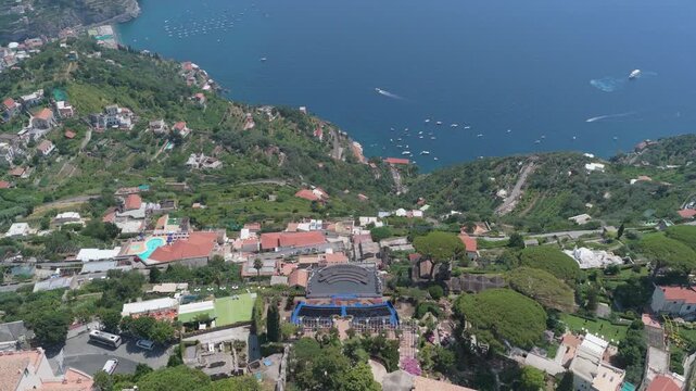 Aerial view of the outdoor stage at Villa Rufolo surrounded by lush gardens and historic architecture in Ravello, Campania, Italy.