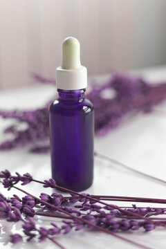 Purple dropper bottle with essential oil and lavender for aromatherapy and wellness