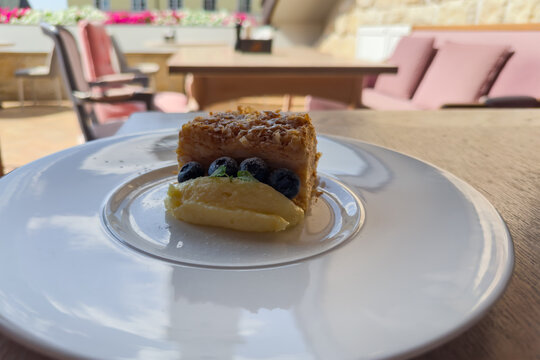 Napoleon cake piece with fresh blueberries on extra portion custard