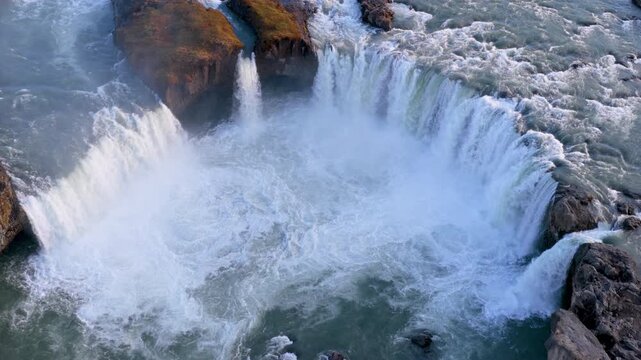 Aerial view of Powerful waterfall Godafoss pouring into a rocky basin. Iceland