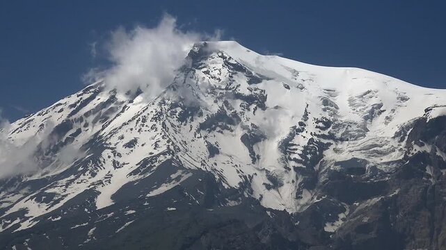 Mount Ararat snow covered volcanic peak rising on eastern Anatolia border with alpine landscape.