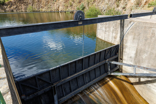 Water flowing from dam sluice gate controlling irrigation
