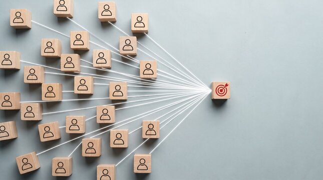 Many wooden blocks with people icons pointing to one block with target icon symbolizing business strategy team collaboration and achieving goals together.