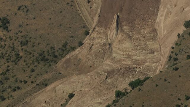 Real landslide mud flows rapidly down a valley creating natural disaster terrain.