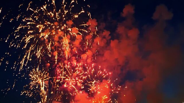 Golden fireworks bursting in the night sky with thick smoke clouds and glowing light trails