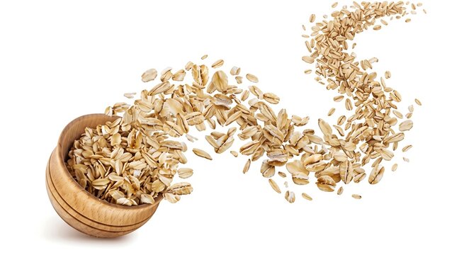Flying oat flakes pouring from wooden bowl on white background