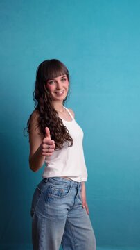 Young woman dancing and showing thumbs up to the camera