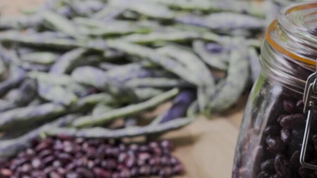 Pinto beans jar placed by hand on table with green beans, 4K