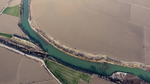 Aerial view of brown fields and irrigation canals surrounding the Nile River alluvial plain.