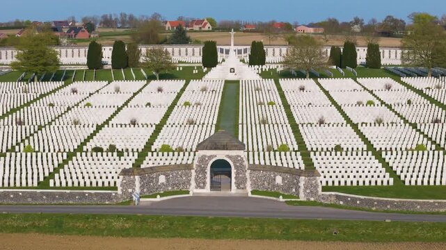 war cemetery tyne cot aerial panorama aligned rows white wwi gravestones towering cross of sacrifice curved memorial wall farmland zonnebeke belgium flanders remembrance lest we forget 1917 aerial