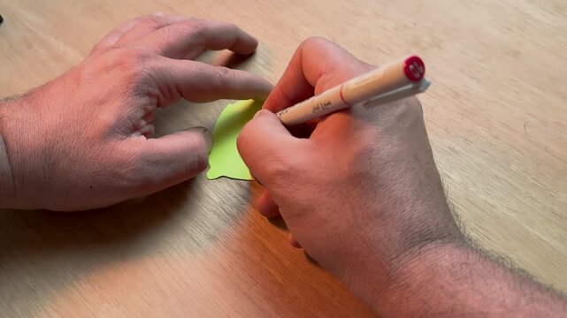 Hand writing traditional Arabic calligraphy with reed pen on paper
