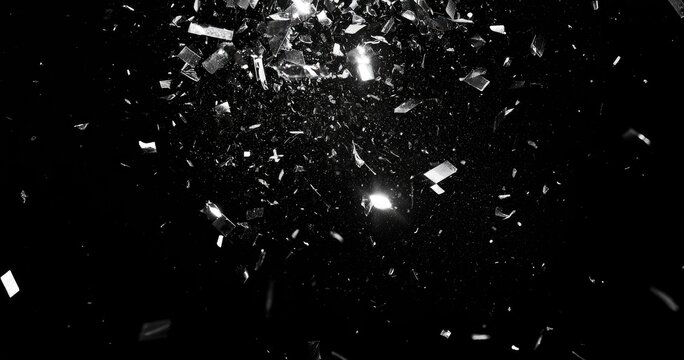Shards of glass explode outwards against a stark black background