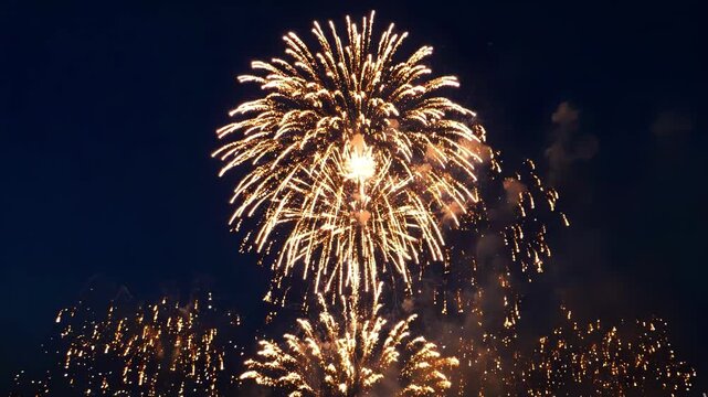Stunning golden fireworks display lighting up the dark night sky during a festive celebration