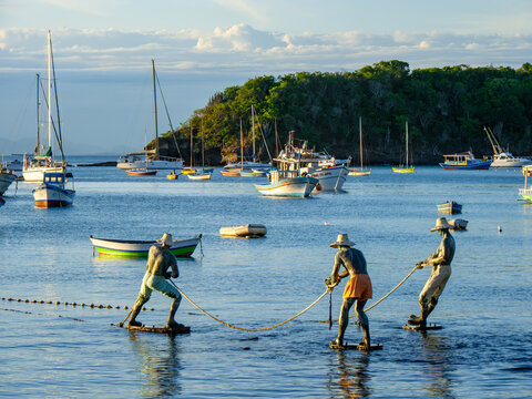 fishermen pulling the fishing net to the beach to get the catch of the day.